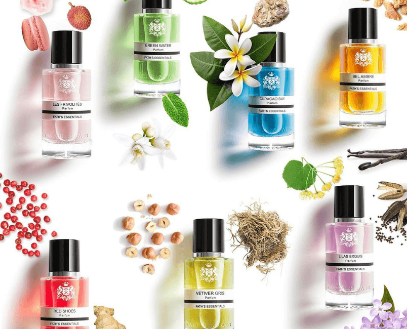 Set di profumi Jaques Fath con ingredienti naturali disposti su uno sfondo bianco.