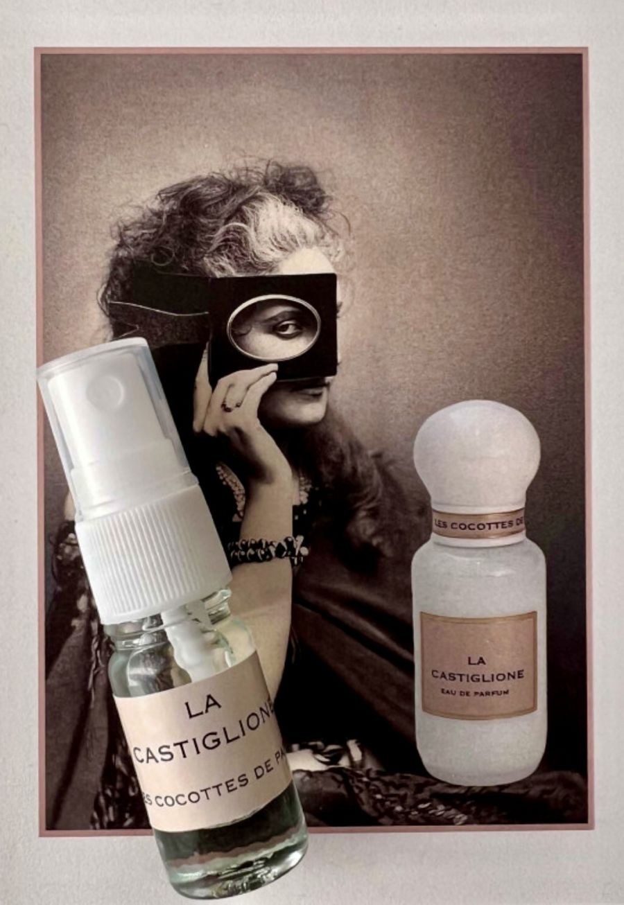 Un ritratto vintage di La Castiglione con due flaconi di profumo Cocottes de Paris, uno trasparente e uno bianco, in primo piano.