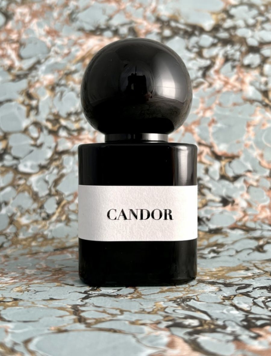 Flacone di Chapel Factory Candor Eau de Parfum con tappo sferico nero e vetro nero. L'etichetta bianca riporta il nome del profumo su uno sfondo bianco, presenti nella boutique Cloud Concept Store di Brescia