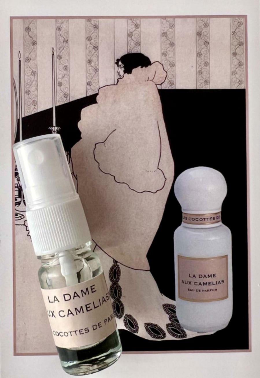 Due flaconi di profumo La Dame aux Camélias di Cocottes de Paris davanti a un’illustrazione vintage con silhouette femminile e sfondo rosa, presenti nella boutique Cloud Concept Store di Brescia